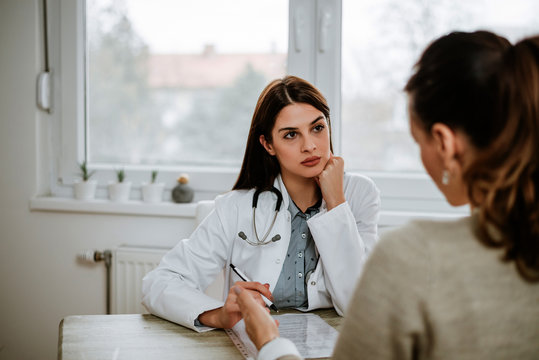 Serious Doctor Listening To A Patient.