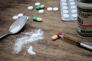 Different drugs, syringe and tablets, money