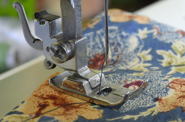 Parts of sewing machine: needle bar, presser foot, needle Plate, feed dog and needle with a thread threaded.