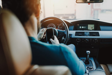 Man sitting in car and looking at his mobile phone. 