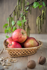 Apples lie in a wicker basket in the form of a heart.