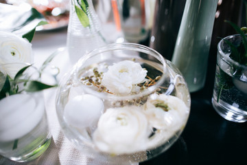 Decor with beautiful white flowers in glass jars on the wedding table