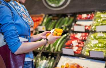Womans hands holding paprika in a store