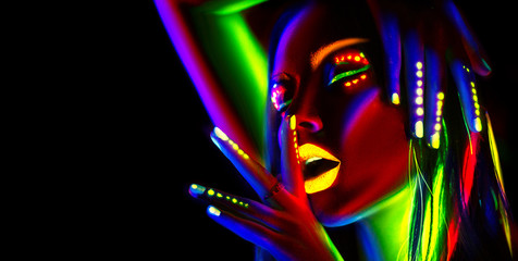 Fashion model woman in neon light. Portrait of beautiful model girl with colorful fluorescent makeup