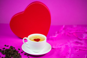 Cup of coffee with big red heart in the background
