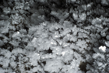 background: a section of the cave wall covered with large crystals of ice