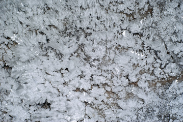 background: a section of the cave wall covered with large crystals of ice