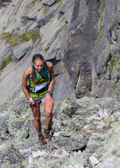Young woman running on a dry mountain path.