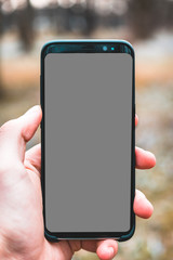 Fototapeta na wymiar Smartphone in der Hand, graues Display - Greenscreen
