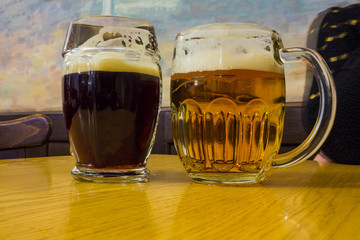 The two glasses of czech beer on a wooden barrel table