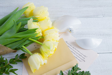 A bouquet of yellow tulips, on a white, wooden, shabby background with Shakespeare poems, an old...