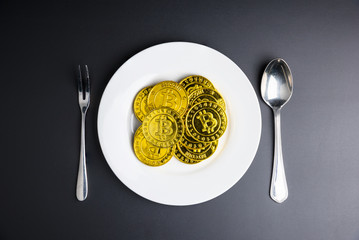 Cryptocurrency golden bitcoins coin in white dish on black background. Digital currency concepts can be used to make online purchases. Shoot at low light.