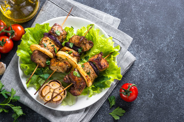 Grilled shish kebab or shashlik on black stone table.