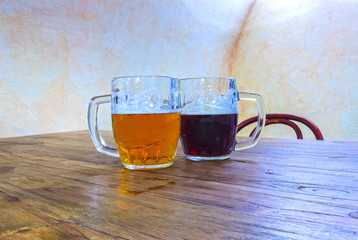 The two glasses of czech beer on a wooden barrel table