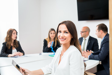 Obraz premium Beautiful business woman is looking at camera and smiling while working in office