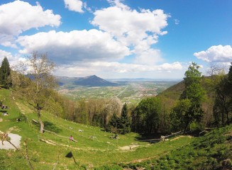 Fototapeta na wymiar Val di Susa, beautiful view of the green valley with people standing on the grass from Sacra di San Michele, Torino, Italy