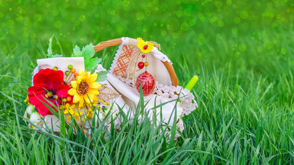 Easter basket in green grass, on a blurred background of meadow with bokeh effect