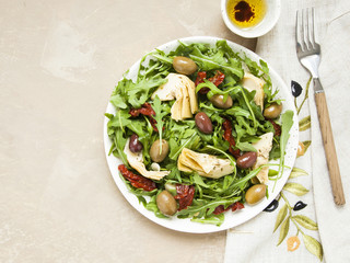 Tasty vegetarian salad with artichoke, rocket, sun-dried tomatoes and olives. 