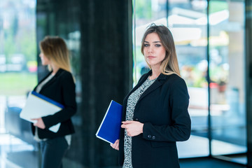 Handsome confident business woman holding files. Portrait of a handsome CEO. Handsome executive business woman at the workspace office