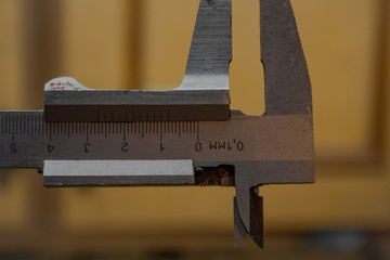 Marco focus set on a vernier caliper. Workshop and tools in the background
