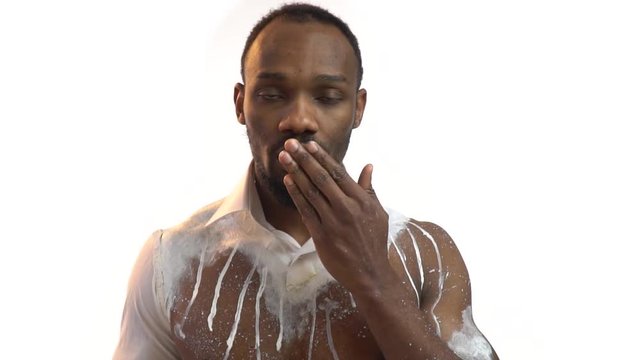 Charming black man in white body art sends an air kiss, congratulations on March 8, slow motion