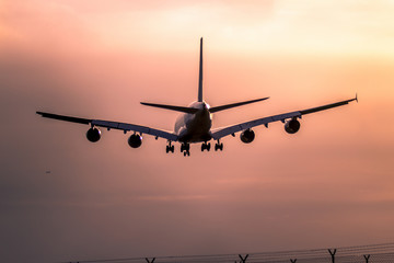 Airplane landing at sunset