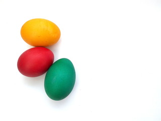 Red, yellow and green Easter eggs on white background.