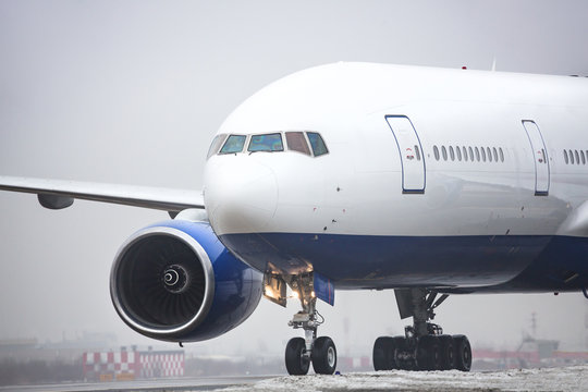 Bad Weather, Aviation, Transportation,  Travel Concept/ Close Up Of Wide-body Airplane Taxing On Runway After Landing, Low-cloud Conditions, Poor Visibility, Foggy Weather In Cold Season, Horizontal