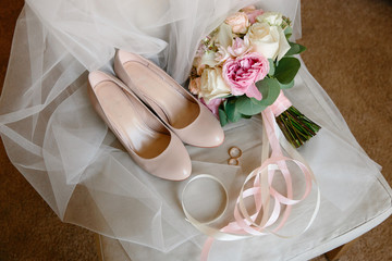beige high-heeled shoes on the chair classic light leather women's shoes wedding shoes on chair, wedding shoes and wedding bouquet this stylish bouquet with roses
