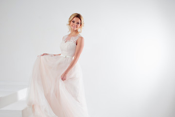 Fototapeta na wymiar Portrait of a beautiful girl in a wedding dress. Bride, white background, free space on the right