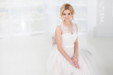 Portrait of a beautiful girl in a wedding dress. Bride in a luxurious dress on a white background, close-up