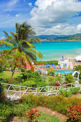 GRENADA ISLAND - MAR 7, 2009: View of Grand Anse beach and luxury hotel from tropical garden on sunny beautiful day. This island is a sovereign state in the southeastern Caribbean Sea.