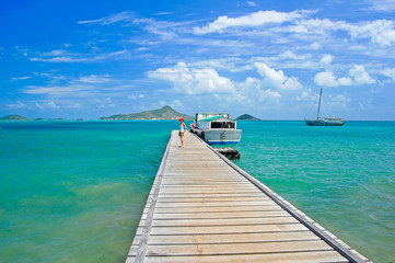 Young woman tourist on wooden jetty and beautiful Caribbean Sea, Carriacou Island