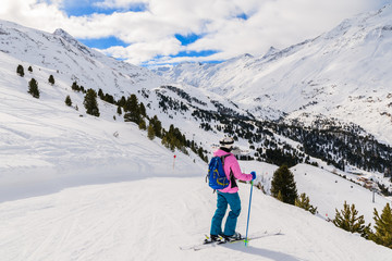 Fototapeta na wymiar Young woman skier on slope and looking at beautiful mountain panorama in winter season, Obergurgl-Hochgurgl ski area, Austria
