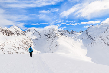Fototapeta na wymiar Unidentified tourist walking on snow in beautiful mountains during winter season, Obergurgl-Hochgurgl ski area, Austria