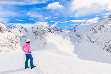 Fototapeta na wymiar Young woman skier looking at beautiful mountains in winter season, Obergurgl-Hochgurgl ski area, Austria