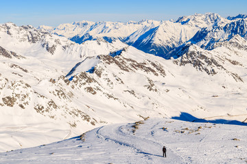 Fototapeta na wymiar Unidentified skier climbing in mountains in Solden ski area on beautiful sunny winter day, Tirol, Austria