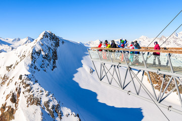 SOLDEN SKI RESORT, AUSTRIA - JAN 29, 2018: Skiers looking at mountains from platform in Solden ski area on beautiful sunny winter day, Tirol, Austria. - obrazy, fototapety, plakaty