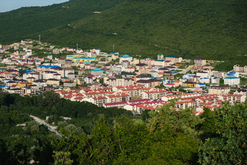 Small town in the mountain gorge. Beautiful view from a height. Summer evening in mountain.
