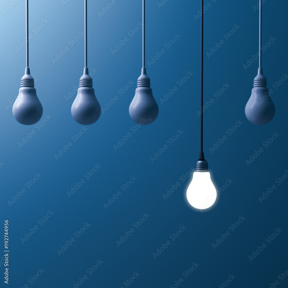 Poster one hanging light bulb glowing and standing out from unlit incandescent bulbs on dark blue backgroun