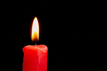 Red candle isolated on black background