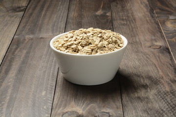 Avena cruda o copos sobre fondo de madera