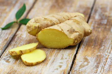 Slices of fresh ginger on rustic wooden surface
