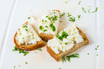 3 slice bread with curd cheese and chive on white board.