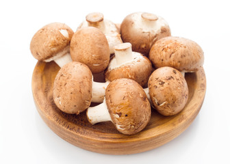 group of whole mushrooms on wooden tray, isolated on white background