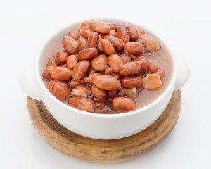 red beans in white crockery casserole on wooden board, isolated on white background