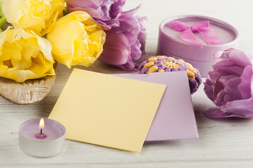 Yellow purple notes, tulips and lit candle