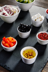 Ingredients to Greek salad on wooden background