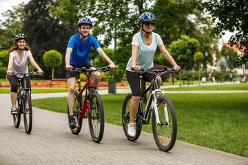 Healthy lifestyle - people riding bicycles in city park