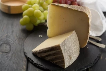 Fototapeten Tasting of ancient french demi soft cheese Tomme from French Alps, made from cow, goat or sheep skim milk, low fat french cheese © barmalini